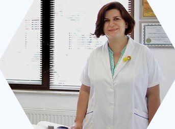 Dr. Camelia Rodica Dron, în halat alb, în cabinet